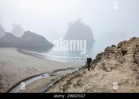 USA, Oregon, Brookings, Senior Frau, die auf der Düne über dem Strand steht Stockfoto