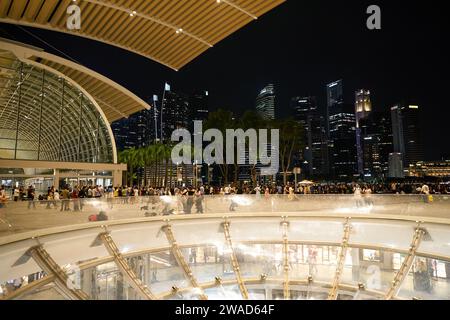 SINGAPUR - 05. NOVEMBER 2023: Regen Oculus in Marina Bay Sands mit Singapur im Hintergrund bei Nacht. Stockfoto