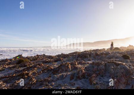 Südafrika, Hermanus, Junge (10-11), der auf Felsen am Kammabaai Beach spaziert Stockfoto