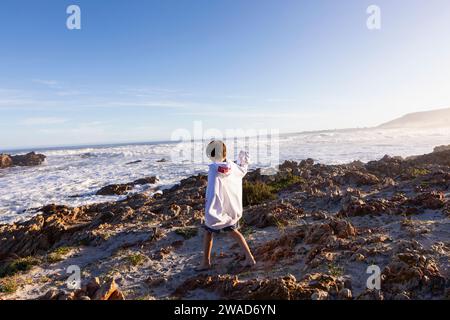 Südafrika, Hermanus, Junge (10-11), der auf Felsen am Kammabaai Beach spaziert Stockfoto