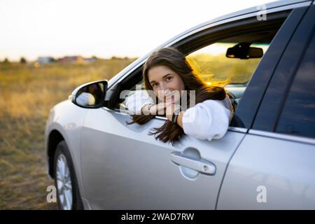 Porträt der jungen Frau, die durch Autofenster Stockfoto