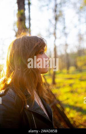 Seitenansicht einer Frau, die am sonnigen Tag den Wald betrachtet Stockfoto