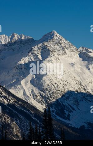 Ein dramatischer Blick auf einen schneebedeckten Gipfel vor einem blauen Himmel vom Whistler Mountain, BC, Kanada. Stockfoto