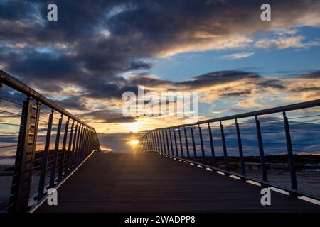 Die Fußgängerbrücke zum Oststrand bei Sonnenaufgang. Lossiemouth, Morayshire, Schottland Stockfoto