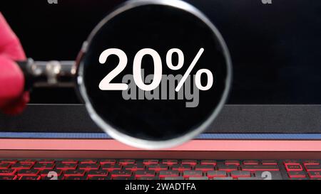 20 % Text auf dem Monitor durch eine Lupe Stockfoto