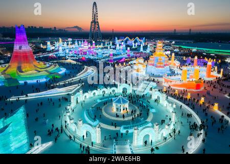 (240104) -- HARBIN, 4. Januar 2024 (Xinhua) -- dieses Luftfoto, aufgenommen am 31. Dezember 2023, zeigt Touristen, die Spaß in der Harbin Ice-Snow World in Harbin, nordöstlicher chinesischer Provinz Heilongjiang haben. Die Provinz Heilongjiang verfügt über reichlich Eis- und Schneeressourcen, was sie zu einem beliebten Reiseziel für Wintertourismus in China macht und zahlreiche Touristen aus dem in- und Ausland während der Neujahrsferien anzieht. Die „ICE City“ Harbin, die Hauptstadt der Provinz Heilongjiang, begrüßte fast 3,05 Millionen Besucher und erzielte während des Urlaubs 5,91 Milliarden Yuan (etwa 832,39 Millionen US-Dollar) an Tourismuseinnahmen Stockfoto