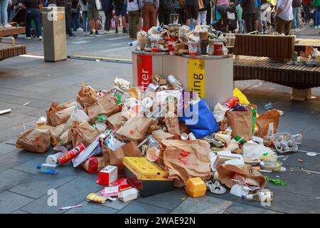 Überfüllte Müll- und Recyclingbehälter, umgeben von Fast Food- und Getränkecontainern. Auckland, Neuseeland Stockfoto