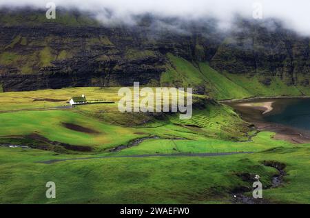 Grüne Berglandschaft mit alten Häusern auf den Färöern, Saksun Stockfoto