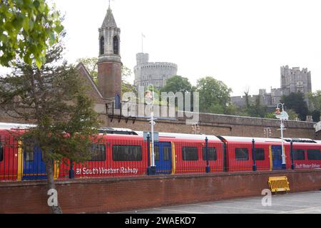 Ein Zug fährt am Bahnhof in Windsor an und Windsor Castle dahinter in Berkshire in Großbritannien Stockfoto