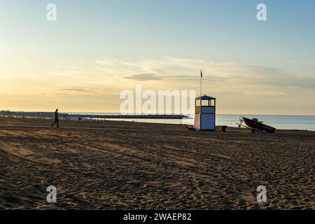 Sonnenaufgang über der Küste mit Liegestühlen und einem Rettungsboot Stockfoto