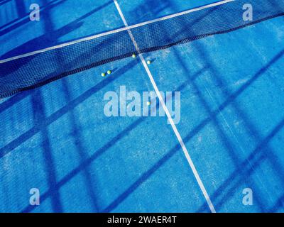 Drohnenblick auf einen blauen Paddle-Tennisplatz und fünf Bälle Stockfoto