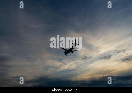 Silhouette eines Flugzeugs vor dem bewölkten Himmel, der am frankfurter Hauptflughafen landet Stockfoto