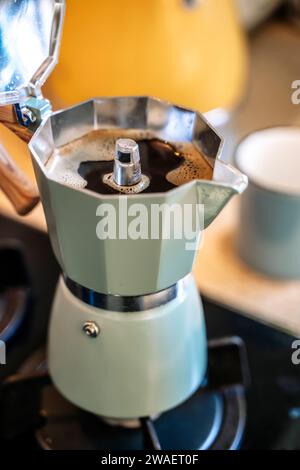 Geyser-Kaffeemaschine mit Kaffeegetränk auf dem Herd in der Küche. Hochwertige Fotos Stockfoto