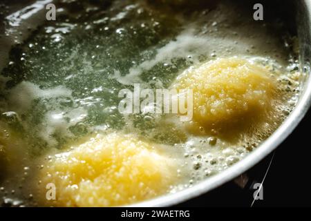 Bayern, Deutschland - 25. Dezember 2023: Kartoffelklöße in einem Kochtopf mit kochendem Wasser *** Kartoffelklöße in einem Kochtopf mit kochendem Wasser Stockfoto