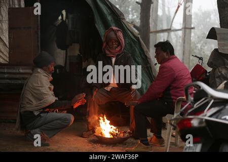 (240104) -- AMRITSAR, 4. Januar 2024 (Xinhua) -- Menschen sitzen in der Nähe eines Feuers, um sich warm zu halten, im Amritsar-Bezirk im nördlichen Punjab-Bundesstaat Indien, 4. Januar 2024. (Fil/Xinhua) Stockfoto