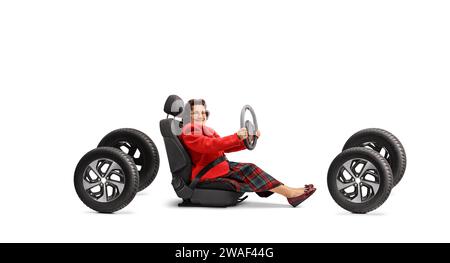 Ältere Frau sitzt auf einem Autositz auf vier Reifen und fährt isoliert auf weißem Hintergrund Stockfoto