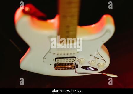 Eine Nahaufnahme einer weißen E-Gitarre auf einem Stand Stockfoto