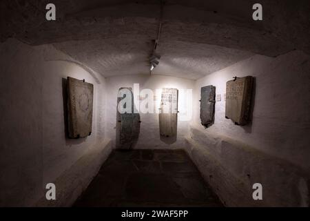 Katakombenbereich, in dem sich Überreste von antiken Grabsteinen befinden, die früher in der Kathedrale von Nidaros ruhten, die sich in der historischen Gegend von Trondhem befindet. Dieses Denkmal ist ein majestätisches gotisches Gebäude, das 1070 über dem Grabmal von St. Olaf erbaut wurde. Es ist bekannt für seine beeindruckende Architektur, mit einer reich verzierten Fassade und einer Mischung von Stilen über die Jahrhunderte. Das Innere beherbergt einen hervorragenden Altaraufsatz und Buntglasfenster. Neben seiner religiösen Bedeutung war es der Krönungsort der norwegischen Monarchen und ein Wallfahrtsziel. Die zentrale Lage und die charmante Umgebung Stockfoto