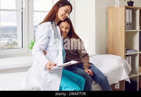 Nette und niedliche Krankenschwester unterstützt Teenager Mädchen Patienten vor der medizinischen Untersuchung. Stockfoto