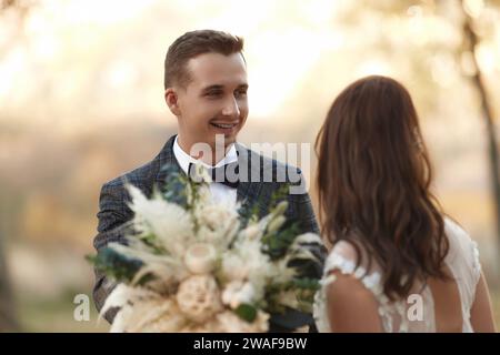 Porträt der Braut in weißem Hochzeitskleid und des Bräutigams im Freien Stockfoto