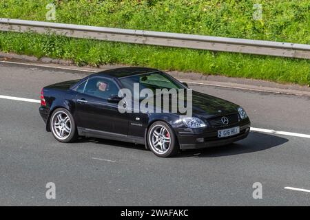 1999 90er Jahre Schwarz Mercedes Benz SLK 230 Kompressor Auto SLK230 Kompressor Auto Auto Car Roadster Benzin 2295 ccm kompakter Luxus-Roadster; Fahrt auf der Autobahn M6 im Großraum Manchester, Großbritannien Stockfoto