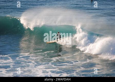 Professioneller Surfer reitet eine Welle im Meer. Sopelana Strand in der Nähe von Bilbao (Baskenland). Männer fangen Wellen im Ozean. Heck Rutsche Wassersurf, Action Stockfoto