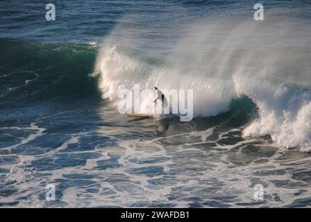 Professioneller Surfer reitet eine Welle im Meer. Sopelana Strand in der Nähe von Bilbao (Baskenland). Männer fangen Wellen im Ozean. Heck Rutsche Wassersurf, Action Stockfoto