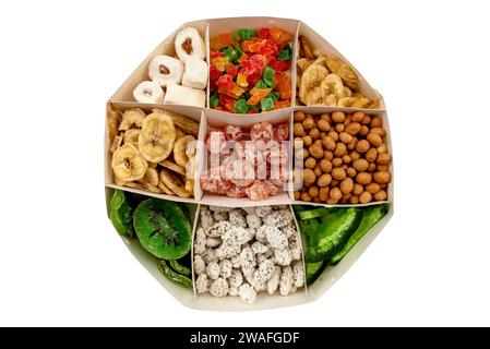 Ein Satz verschiedener getrockneter Früchte in einem Karton auf weißem Hintergrund. Blick von oben. Getrocknete Kiwi, kandierte Früchte, Bananen und Nüsse Stockfoto