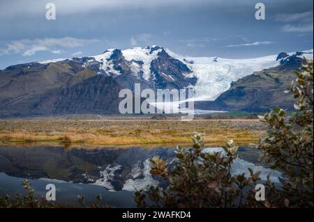 Islands vulkanische Landschaft und seine Gletscher in der Ferne um Vatnajokull. Mit der Reflexion im Wasser. Stockfoto