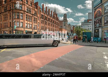 Eine Stretchlimousine von Hummer, die an einer Straßenkreuzung im Stadtzentrum abbiegt. Fahren, Party, Nachtleben, Luxusreisen, Prominente-Konzept Stockfoto