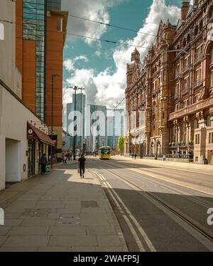 Straßenbahnlinien führen am Edwardian Baroque Midland Hotel entlang der Lower Mosley Street zum Axis Tower und anderen Wolkenkratzern im Stadtzentrum von Manchester. Stockfoto