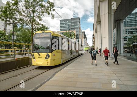 Eine Metrolink-Straßenbahn, die durch das dynamische Stadtzentrum von Manchester fährt, Ein schnelles und umweltfreundlicheres öffentliches Verkehrsmittel. Stockfoto
