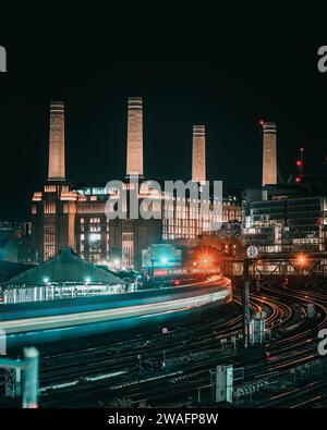 Der Zug fährt nachts am Battersea-Kraftwerk vorbei Stockfoto
