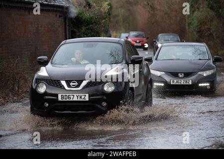 Sonning, Berkshire, Großbritannien. Januar 2024. Autos fahren durch das Hochwasser in Sonning, Berkshire. Ein Hochwasseralarm für die Themse in Sonning ist in Kraft. Quelle: Maureen McLean/Alamy Live News Stockfoto