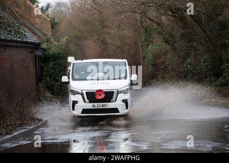 Sonning, Berkshire, Großbritannien. Januar 2024. Autos fahren durch das Hochwasser in Sonning, Berkshire. Ein Hochwasseralarm für die Themse in Sonning ist in Kraft. Quelle: Maureen McLean/Alamy Live News Stockfoto