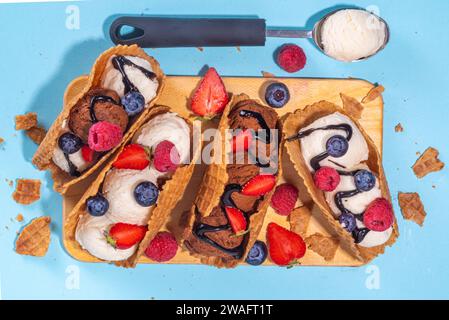 Verschiedene süße Taco-Eiscreme. Waffel-Taco-Muscheln mit Schokolade- und Vanillegeschmack, Eiscreme mit verschiedenen Früchten, Beeren und Garnierungen Stockfoto