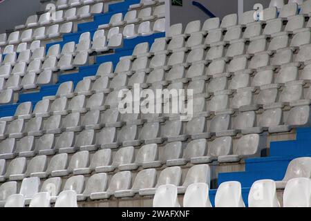 Steht auf einem Fußballfeld, wo Sie die weißen und blauen Plastiksitze sehen können Stockfoto