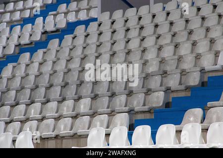 Steht auf einem Fußballfeld, wo Sie die weißen und blauen Plastiksitze sehen können Stockfoto