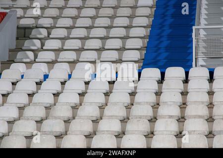 Steht auf einem Fußballfeld, wo Sie die weißen und blauen Plastiksitze sehen können Stockfoto