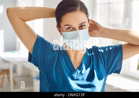 Ernsthafte Frau Doktor in Gesichtsmaske schaut in die Kamera im Krankenhaus Stockfoto