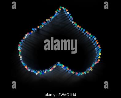 Eine Herzform aus mehrfarbigen Streichhölzern auf Schwarz Stockfoto