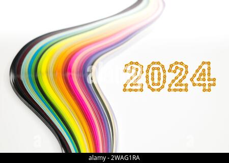 Abstraktes Farbwellengewelltes Regenbogenstreifenpapier auf weißem Hintergrund mit 2024 Happy New Year gemacht aus Kettengliedern Stockfoto