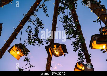 Bücher mit Glühbirnen und Ornamenten auf Holzpfosten mit dem Himmel im Hintergrund Stockfoto