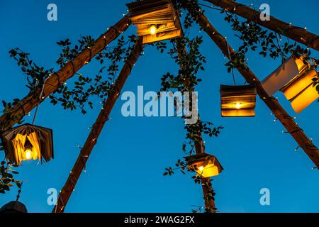 Bücher mit Glühbirnen und Ornamenten auf Holzpfosten mit dem Himmel im Hintergrund Stockfoto