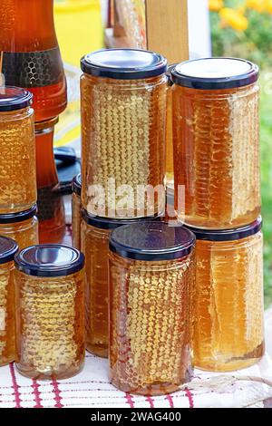 Bio-Honigkamm und andere gesunde natürliche Lebensmittel in Glasgläsern verkauft draußen auf einem Markt Stockfoto