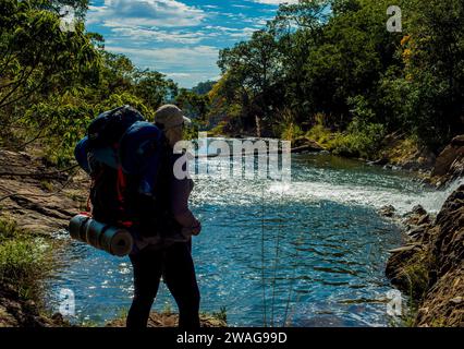Wanderer mit Rucksack auf dem Hintergrund eines Bergflusses Stockfoto