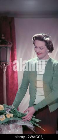 1950er Jahre, historisch, eine elegante junge Dame, Mitte 20, die die neueste Langarm-Strickjacke aus reiner Schurwolle und Oberteil mit Rundhalsausschnitt nachempfunden hat, England, Großbritannien. Stockfoto