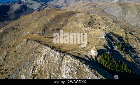 Rocca Calascio 2023. Blick aus der Vogelperspektive auf die Kirche Santa Maria della Pietà, erbaut um 1500 mit Blick auf die umliegenden Berge. Januar 2024 Abruz Stockfoto