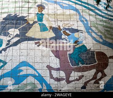 Ein Mosaik mit einem traditionellen kasachischen Thema - Kampf auf Pferden, Krieger in traditioneller Kleidung. 1968. Almaty Kasachstan Stockfoto