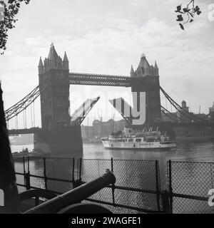 1960er Jahre, historisches Dampfschiff, Royal Sovereign, unter der Tower Bridge, an der Themse, London, England, Großbritannien. Der Vergnügungskreuzer wurde 1948 von William Denny & Brothers in Dumbarton für die GSNSC gebaut und nahm Passagiere auf Reisen zwischen Tower Pier in London, über Southend, Küstenstädten in Kent und Häfen an der französischen Küste mit. Stockfoto